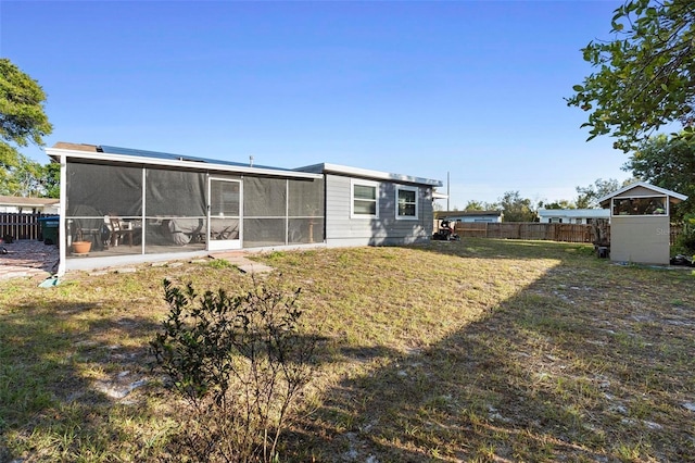 back of property featuring a sunroom and a yard