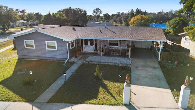 ranch-style house featuring a carport and a front lawn