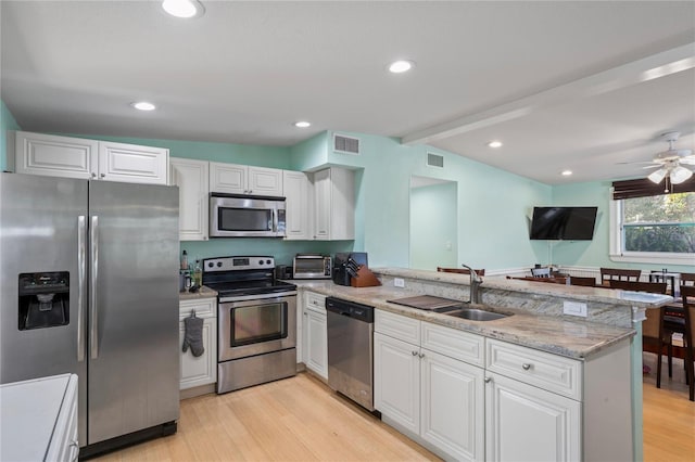 kitchen featuring kitchen peninsula, white cabinetry, and stainless steel appliances