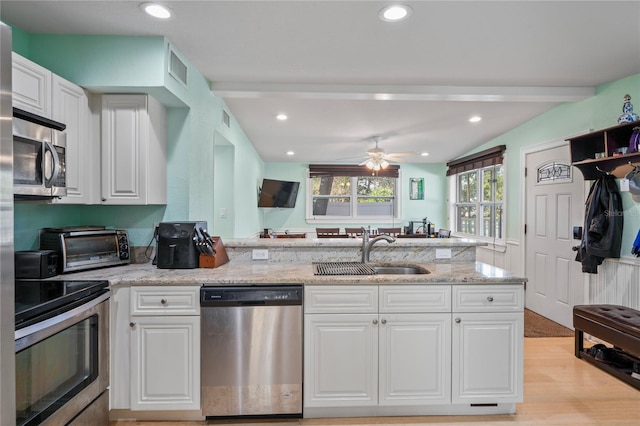 kitchen with white cabinets, stainless steel appliances, ceiling fan, and sink