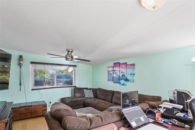 living room featuring a textured ceiling, hardwood / wood-style flooring, and ceiling fan