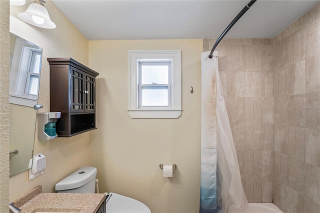 bathroom with curtained shower, vanity, and toilet