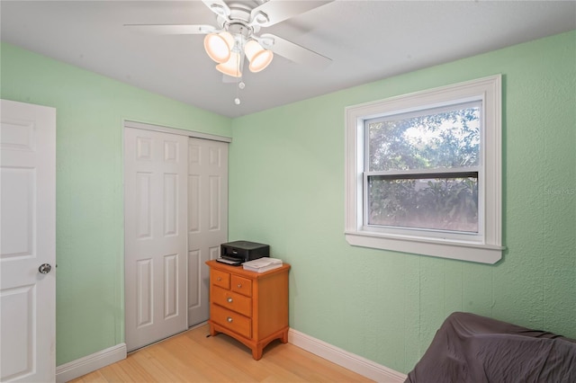 bedroom featuring ceiling fan, light wood-type flooring, and a closet