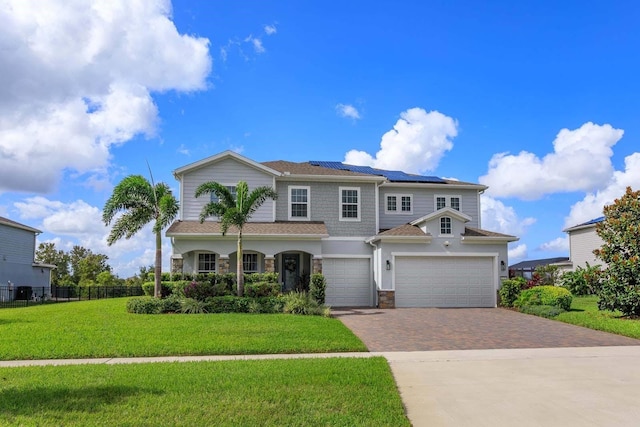 view of front of home with a front lawn, a garage, and solar panels