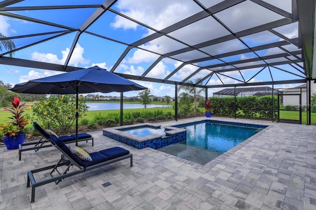 view of pool with an in ground hot tub, a water view, glass enclosure, and a patio area