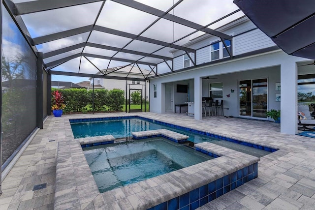 view of pool with ceiling fan, a lanai, an in ground hot tub, a bar, and a patio