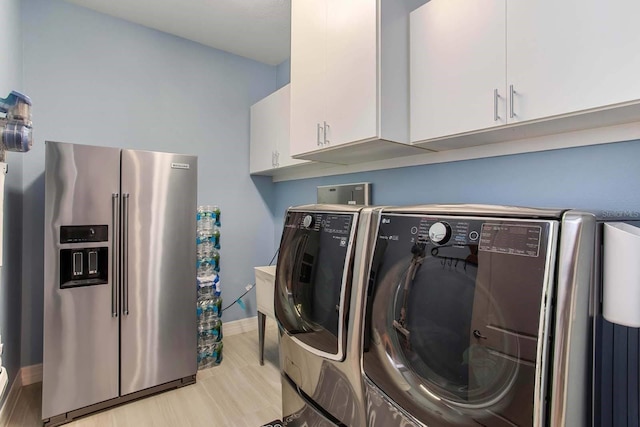 washroom with cabinets, separate washer and dryer, and light hardwood / wood-style floors