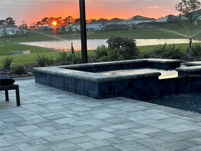 exterior space with a water view, a patio area, and a jacuzzi