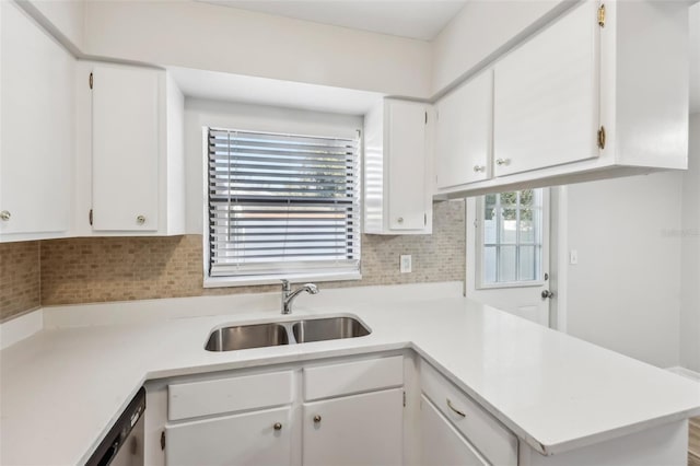 kitchen featuring sink, kitchen peninsula, tasteful backsplash, and white cabinetry