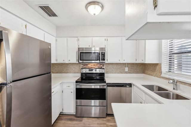 kitchen with sink, white cabinets, and appliances with stainless steel finishes