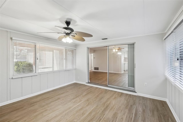 empty room with hardwood / wood-style flooring, ceiling fan, and crown molding