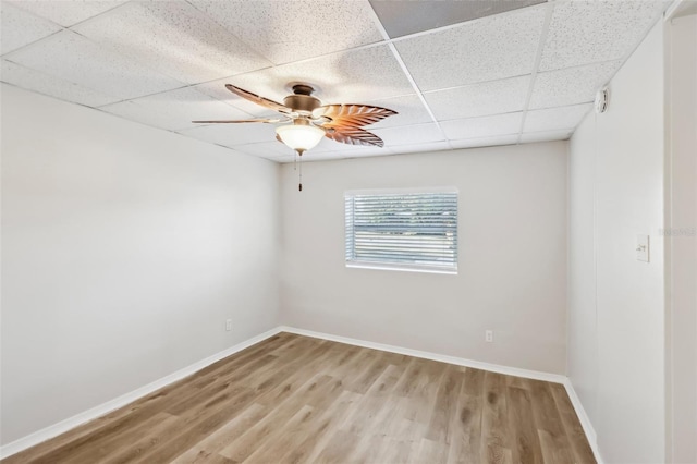 empty room featuring a paneled ceiling, wood-type flooring, and ceiling fan