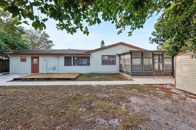 rear view of house featuring a deck and a sunroom