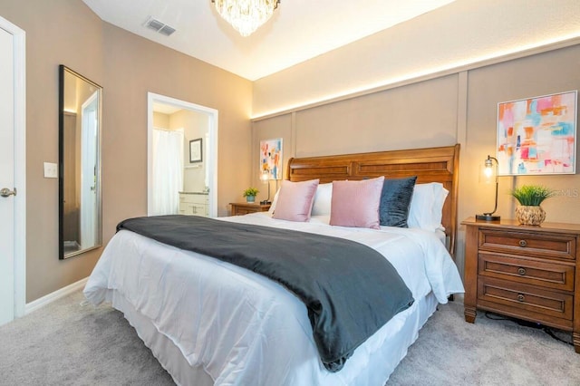 bedroom featuring connected bathroom and light colored carpet