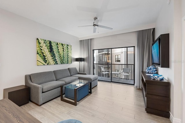 living room featuring light hardwood / wood-style flooring and ceiling fan