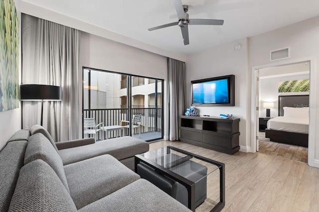 living room with ceiling fan and light wood-type flooring