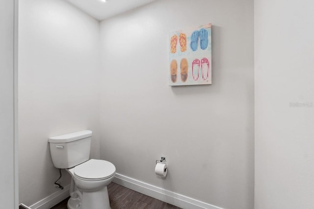 bathroom featuring wood-type flooring and toilet