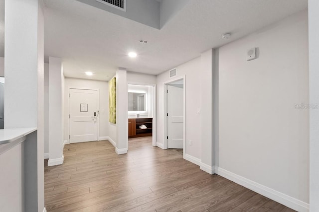 corridor with light hardwood / wood-style flooring