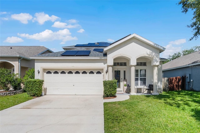 ranch-style house with a front yard, solar panels, and a garage