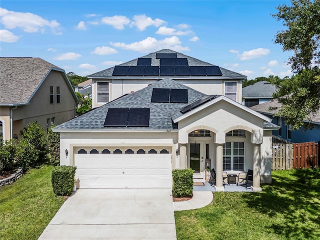 view of front of home featuring solar panels, a garage, and a front lawn