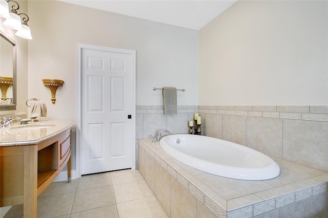 bathroom featuring tile patterned floors, vanity, and tiled bath