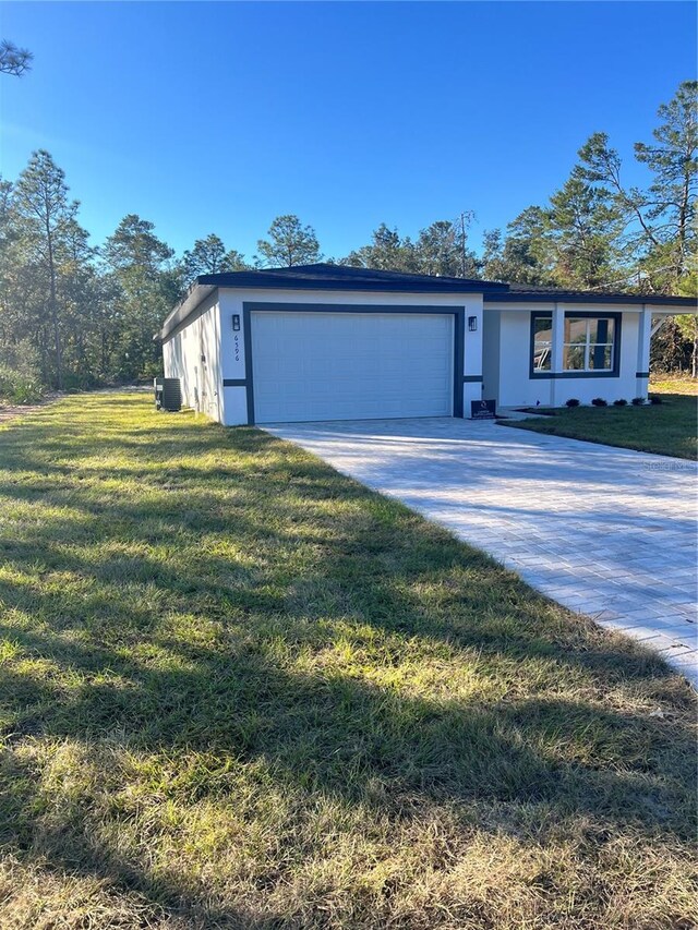 view of front of property featuring a garage and a front lawn