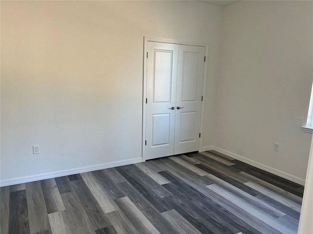 unfurnished room with dark hardwood / wood-style flooring