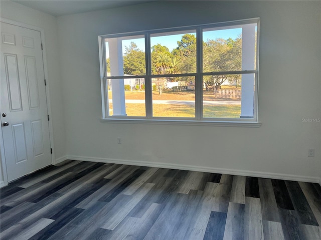 unfurnished room with dark hardwood / wood-style flooring