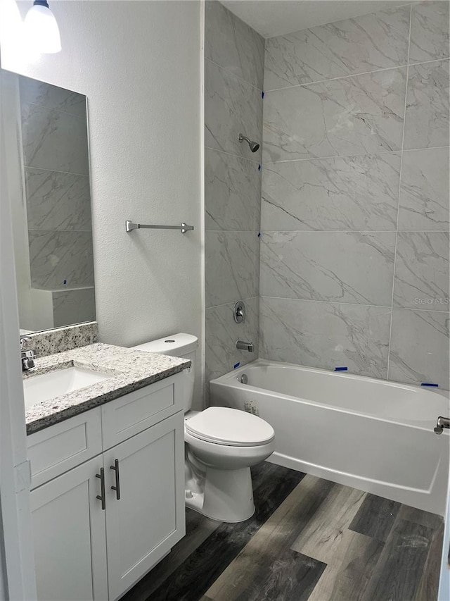 full bathroom featuring vanity, toilet, wood-type flooring, and tiled shower / bath