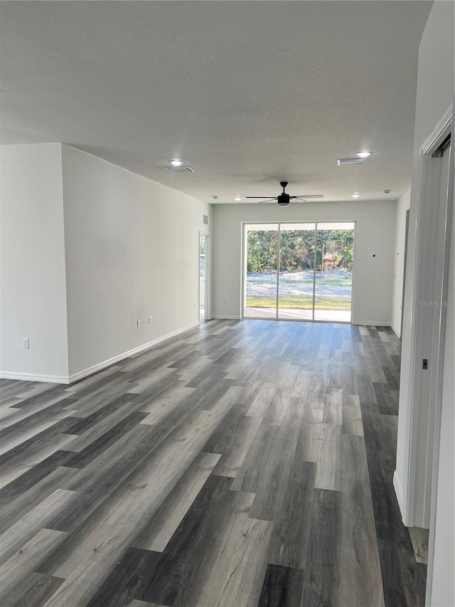 empty room featuring a textured ceiling, dark hardwood / wood-style flooring, and ceiling fan