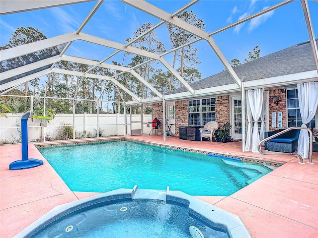 view of swimming pool with an in ground hot tub, a patio, and glass enclosure