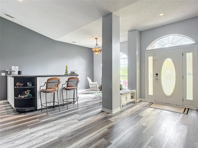 foyer entrance featuring a textured ceiling, hardwood / wood-style flooring, and ceiling fan