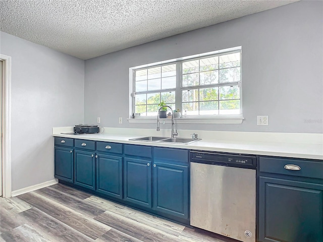 kitchen featuring dishwasher, light hardwood / wood-style floors, blue cabinetry, and sink