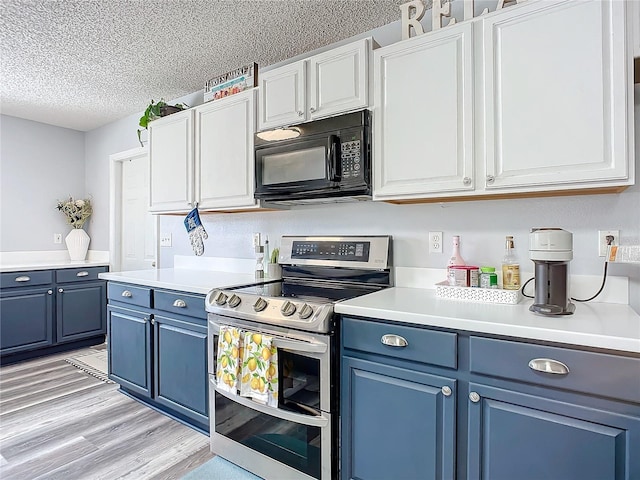 kitchen featuring blue cabinetry, white cabinetry, a textured ceiling, and stainless steel electric range