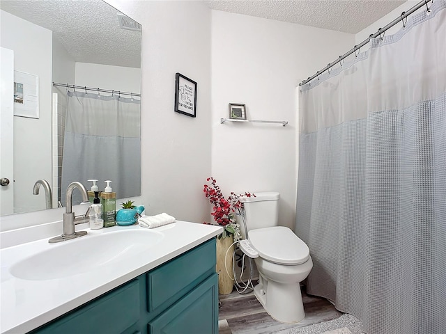 bathroom featuring hardwood / wood-style floors, vanity, a textured ceiling, and toilet