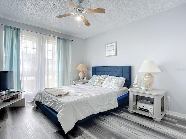 bedroom with wood-type flooring, a textured ceiling, and ceiling fan