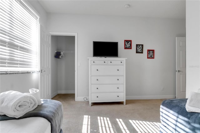 carpeted bedroom featuring multiple windows and a closet