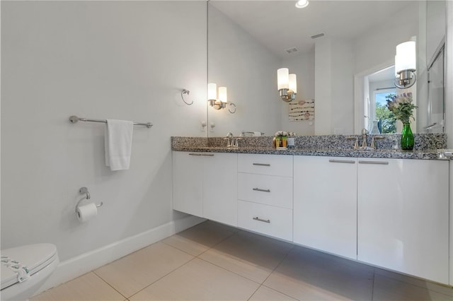 bathroom with tile patterned flooring, vanity, and toilet