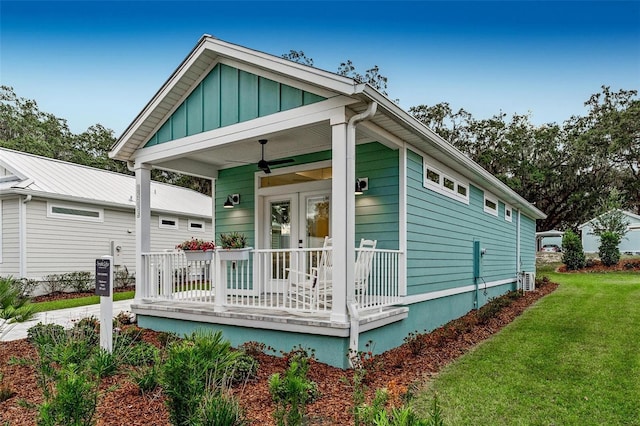 back of property featuring a porch and a yard