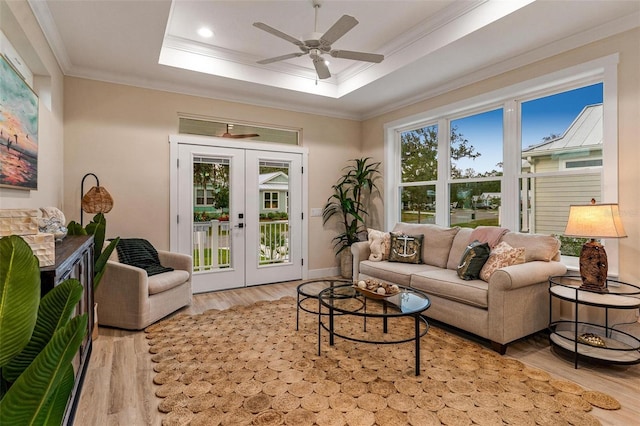 12133 Grand Oak Ln, Oxford, FL 34484 - living room featuring a tray ceiling, light hardwood / wood-style flooring, french doors, and ornamental molding