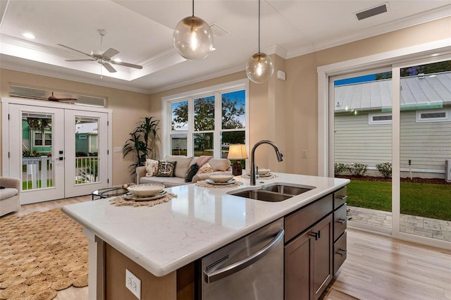 12133 Grand Oak Ln, Oxford, FL 34484 - kitchen with dishwasher, sink, hanging light fixtures, light stone counters, and light hardwood / wood-style flooring