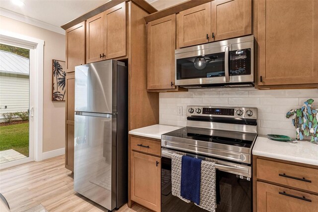 12133 Grand Oak Ln, Oxford, FL 34484 - kitchen featuring backsplash, crown molding, light hardwood / wood-style flooring, and stainless steel appliances