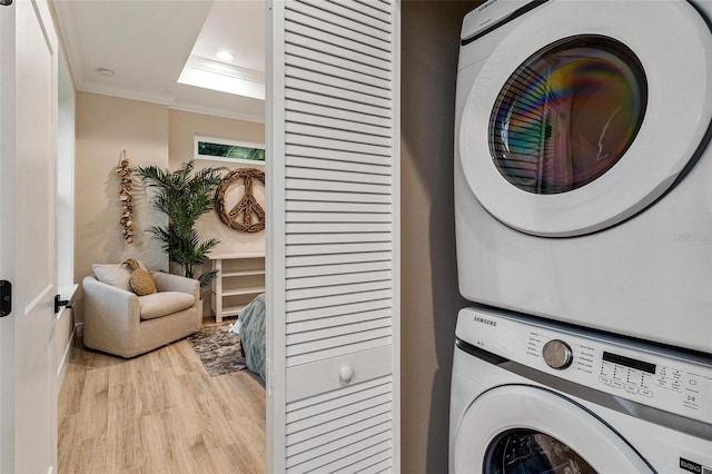 12133 Grand Oak Ln, Oxford, FL 34484 - clothes washing area with light wood-type flooring, crown molding, and stacked washer / drying machine