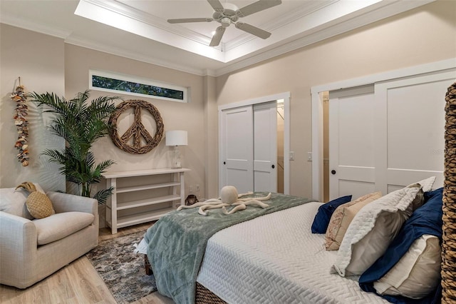 12133 Grand Oak Ln, Oxford, FL 34484 - bedroom with hardwood / wood-style floors, ceiling fan, ornamental molding, and two closets