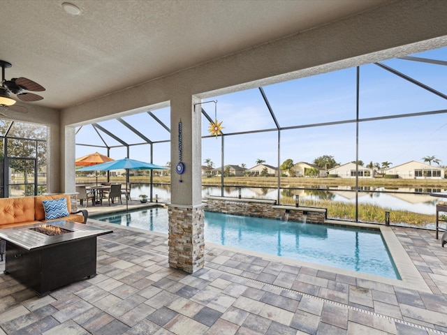 view of swimming pool featuring pool water feature, a patio, a lanai, and a fire pit