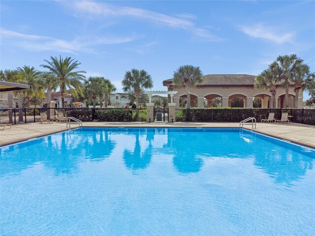 community pool featuring a patio area and fence