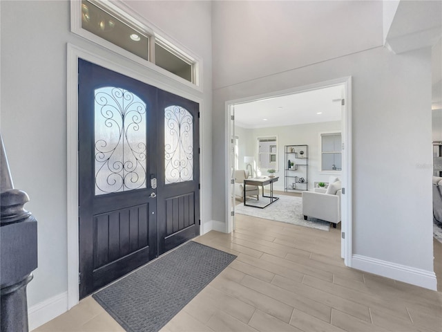 foyer entrance with wood finish floors, french doors, and baseboards