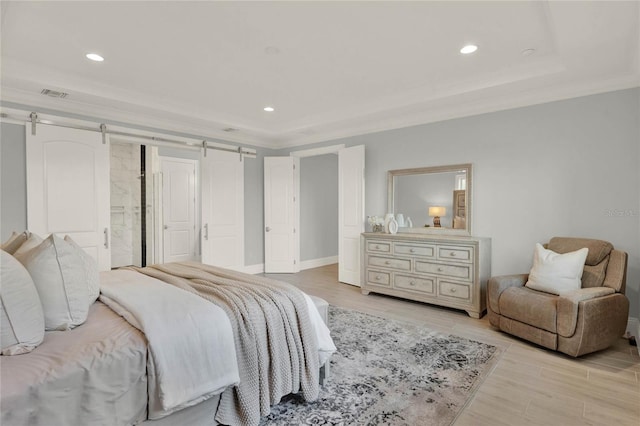 bedroom featuring a barn door, recessed lighting, visible vents, ornamental molding, and light wood finished floors