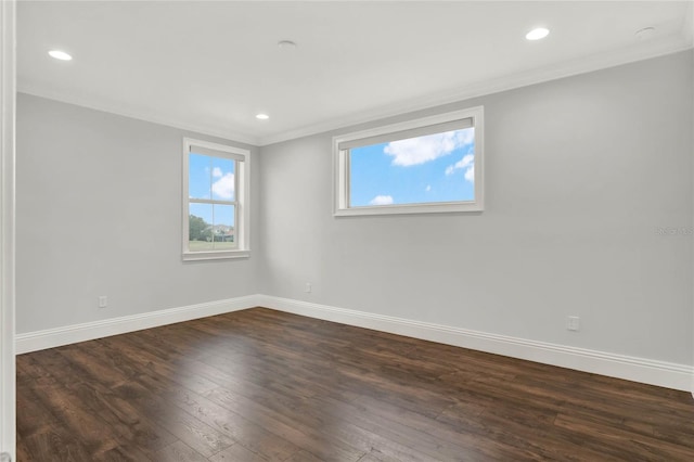 unfurnished room featuring crown molding, dark wood finished floors, and baseboards