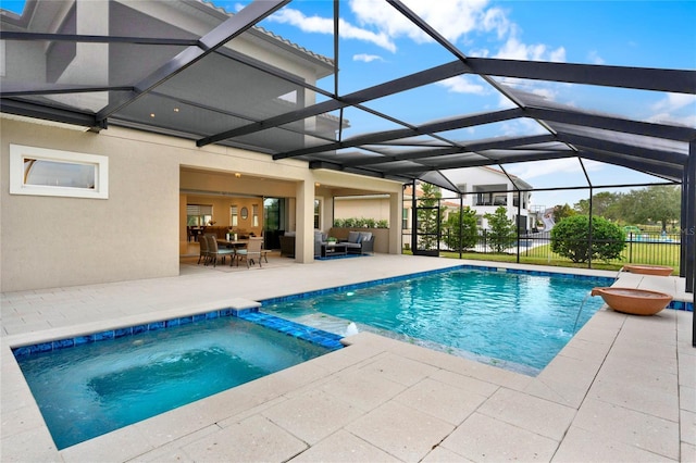 view of swimming pool with a lanai, outdoor lounge area, fence, a pool with connected hot tub, and a patio area